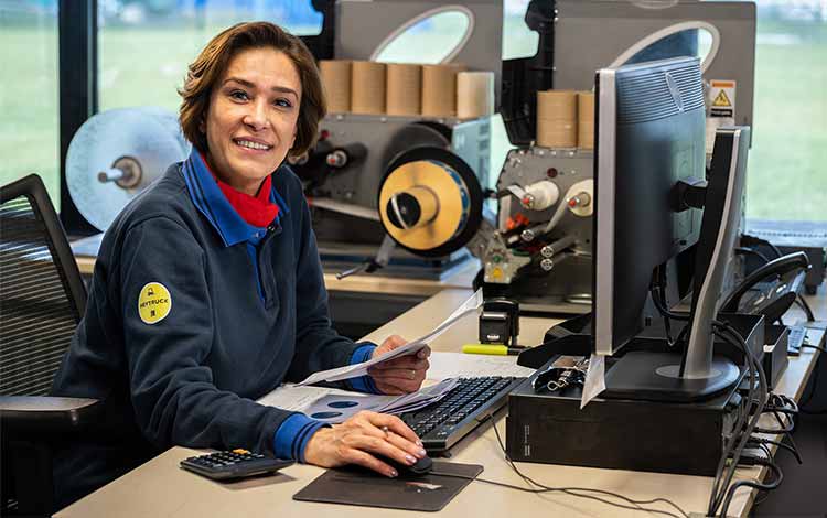 Woman in the office at a computer smiling